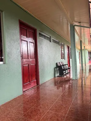 an empty hallway with a red door in a building at Hotel Mavi in El Achiote