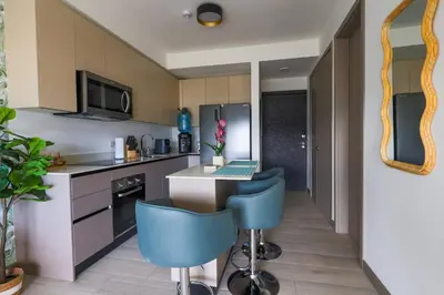 a kitchen with a table and two blue chairs at Modern Apartment located in Trendy San Jose Condo in San José