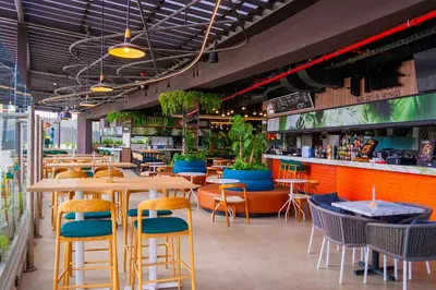 a restaurant with tables and chairs and a bar at Modern Apartment located in Trendy San Jose Condo in San José