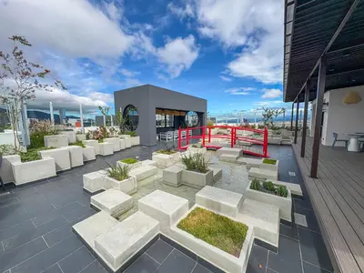 a patio with white benches and plants on a building at Modern Apartment located in Trendy San Jose Condo in San José