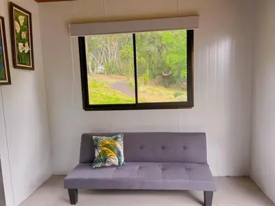 a purple couch in a room with a window at Jalapa's Rural Container Studio in Tilarán