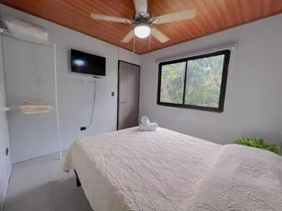 a bedroom with a bed and a ceiling fan at Jalapa's Rural Container Studio in Tilarán
