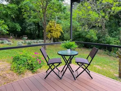 a table with two chairs and a plant on a deck at Jalapa's Rural Container Studio in Tilarán
