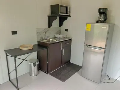 a small kitchen with a sink and a refrigerator at Jalapa's Rural Container Studio in Tilarán