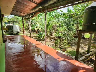 an outside view of a house with water on the floor at Casa de campo Bijagua in Upala