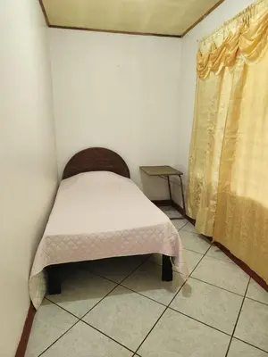 a small bed in a room with a window at Casa de campo Bijagua in Upala