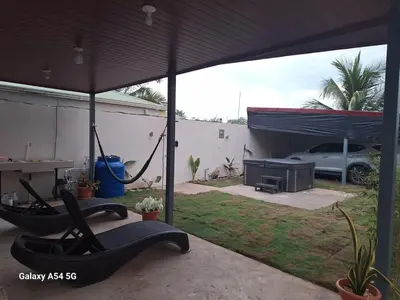 a patio with an umbrella and a car parked in a yard at Apartamento Lantanas in Parrita