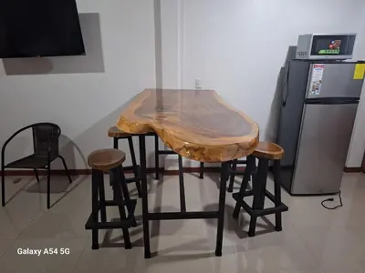 a table with a wooden top and some stools at Apartamento Lantanas in Parrita