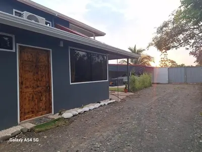 a blue house with a door and a driveway at Apartamento Lantanas in Parrita