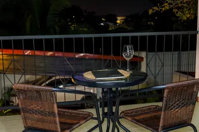 a glass of wine sitting on a table on a balcony at Apartamento Lantanas in Parrita