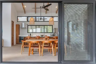 a kitchen and dining room with a wooden table at Luxury villa in Samara beach- Casa Armonía in Sámara