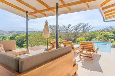 a living room with a couch and chairs on a patio at Luxury villa in Samara beach- Casa Armonía in Sámara