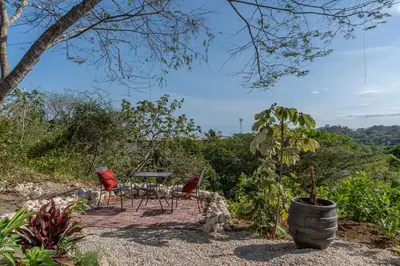 a patio with a table and chairs in a garden at Luxury villa in Samara beach- Casa Armonía in Sámara