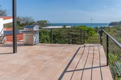a patio with a grill and the ocean in the background at Luxury villa in Samara beach- Casa Armonía in Sámara