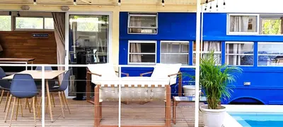 a blue house with a deck with a table and chairs at Bus hotel Playa Barrigona, entre Sàmara y Nosara in Nicoya
