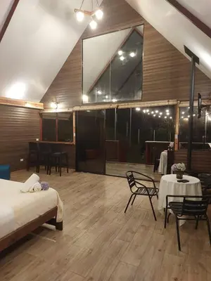 a room with a bed and a table and chairs at Chalet IsaKaEla Volcán Turrialba and Views with charming gardens in Turrialba