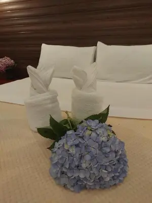 a bed with two bunny towels and a hydrangea at Chalet IsaKaEla Volcán Turrialba and Views with charming gardens in Turrialba