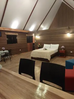 a bedroom with a bed and a table and chairs at Chalet IsaKaEla Volcán Turrialba and Views with charming gardens in Turrialba