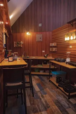 a kitchen with wooden walls and a table and chairs at Chalet IsaKaEla Volcán Turrialba and Views with charming gardens in Turrialba