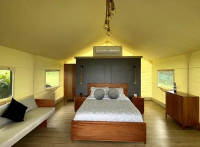 a bedroom with a bed and a bench in it at Safari Tent El Cielo in Santa Ana