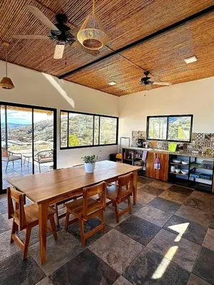 a living room with a wooden table and chairs at Blue Sky Lodge in Nicoya