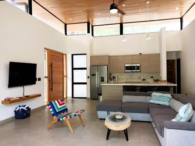a living room with a couch and a kitchen at Casa Mobula - Modern single-level Home, private Pool, near Beach in Potrero