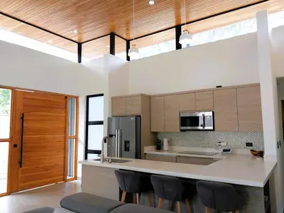a kitchen with a large island with bar chairs at Casa Mobula - Modern single-level Home, private Pool, near Beach in Potrero