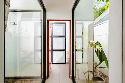 a hallway with glass doors and a plant at Casa Mobula - Modern single-level Home, private Pool, near Beach in Potrero