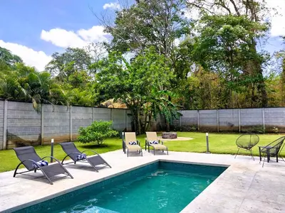 a backyard with a swimming pool with chairs and a fence at Casa Mobula - Modern single-level Home, private Pool, near Beach in Potrero