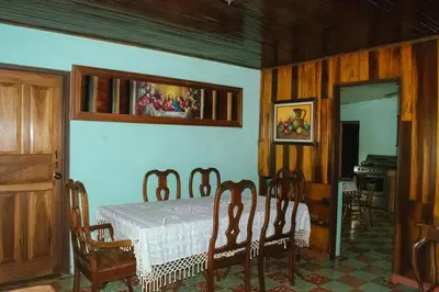a bedroom with a bed and a table and a mirror at Casa Posada Margarita in Bijagua