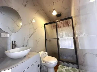 a bathroom with a sink and a toilet and a mirror at Tribu Bungalows Romantic & Confortable 2 in Fortuna