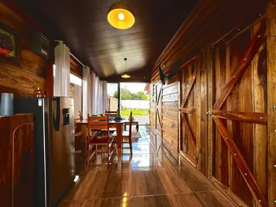 a kitchen with a refrigerator and a table with chairs at Tribu Bungalows Romantic & Confortable 2 in Fortuna