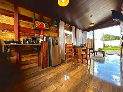 a kitchen with a refrigerator and a table with chairs at Tribu Bungalows 3 Romantic Spot in Fortuna