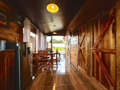 a kitchen with a refrigerator and a table with chairs at Tribu Bungalows 3 Romantic Spot in Fortuna
