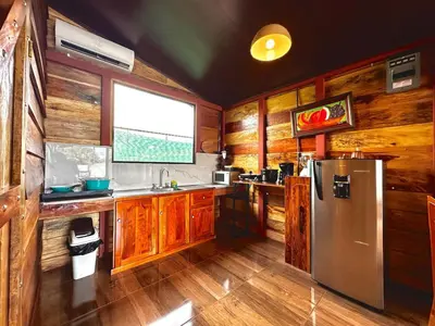 a kitchen with wooden cabinets and a stainless steel refrigerator at Tribu Bungalows 3 Romantic Spot in Fortuna