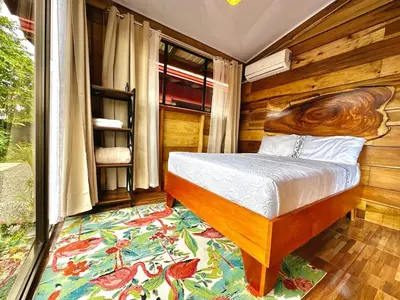 a bedroom with a bed with a wooden wall at Tribu Bungalow 4 Centrally located and comfortable in Fortuna