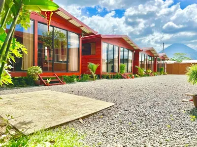 a red house with windows on a gravel driveway at Tribu Bungalows 5 Nice Interior Design in Fortuna