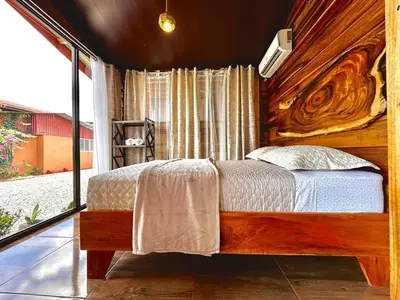 a bedroom with a bed and a large window at Tribu Bungalows 5 Nice Interior Design in Fortuna
