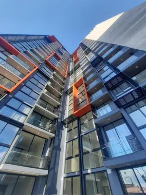 a tall glass building with a red window at Nuevo y moderno loft en Bö Escalante in San José