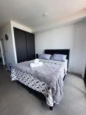a bedroom with a large bed with two towels on it at Nuevo y moderno loft en Bö Escalante in San José