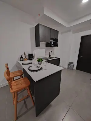 a kitchen with a counter and a wooden chair at Nuevo y moderno loft en Bö Escalante in San José