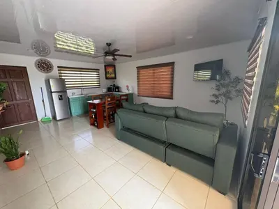 a living room with a couch and a kitchen at Nature Heaven in Jabillos