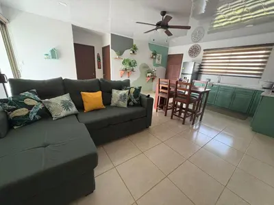 a living room with a couch and a kitchen at Nature Heaven in Jabillos