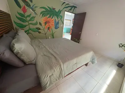 a bedroom with a bed with a flower mural on the wall at Nature Heaven in Jabillos