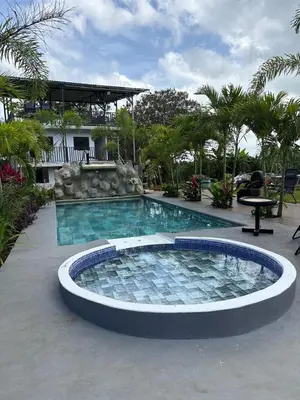 a large swimming pool in a resort with a table at Nature Heaven in Jabillos