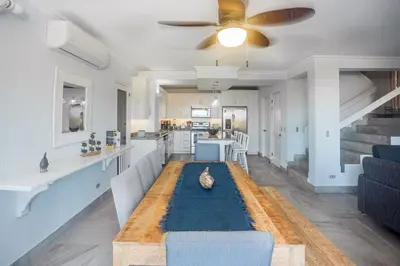 a living room with a couch and a ceiling fan at Oceanview 3BR Villa with 3 Shared Pools and Beachfront Resort Access in Ocotal