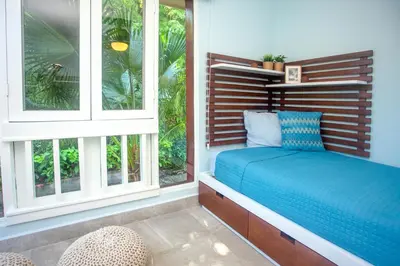 a bedroom with a bed and two windows at Oceanview 3BR Villa with 3 Shared Pools and Beachfront Resort Access in Ocotal