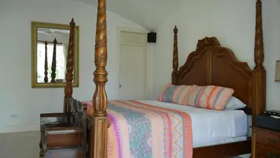 a bedroom with a bed and a mirror at Villa Quebrada Estate in Montezuma