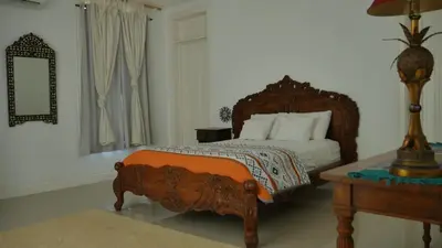 a bedroom with a bed and a table and a mirror at Villa Quebrada Estate in Montezuma