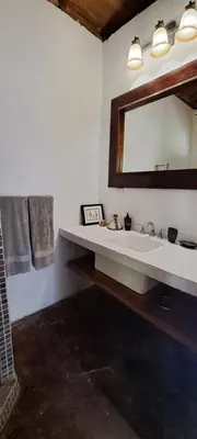 a bathroom with a sink and a mirror at Villa Quebrada Estate in Montezuma